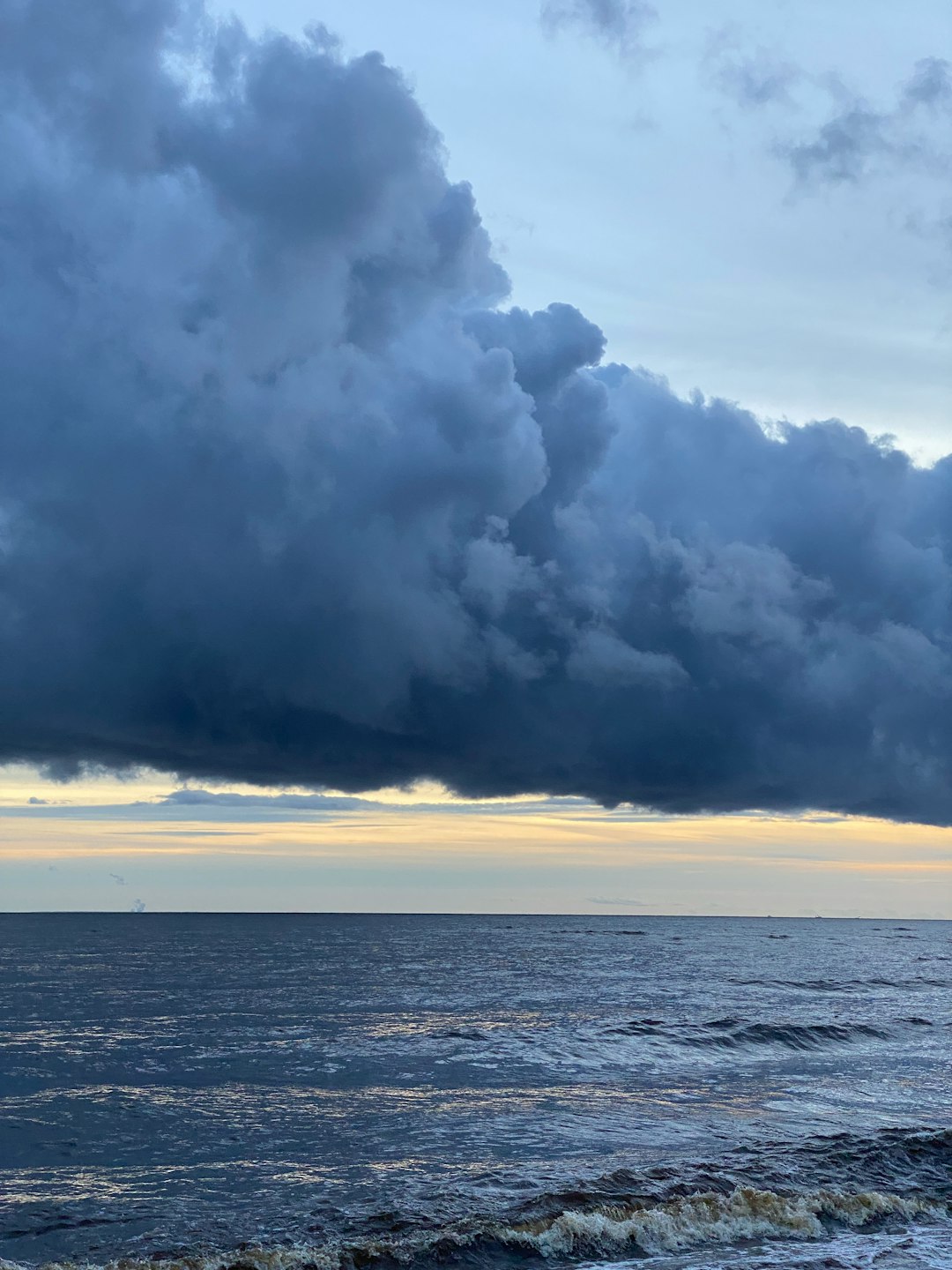 a-cloudy-sky-over-the-ocean-with-a-boat-in-the-distance-vlqinpdbrim